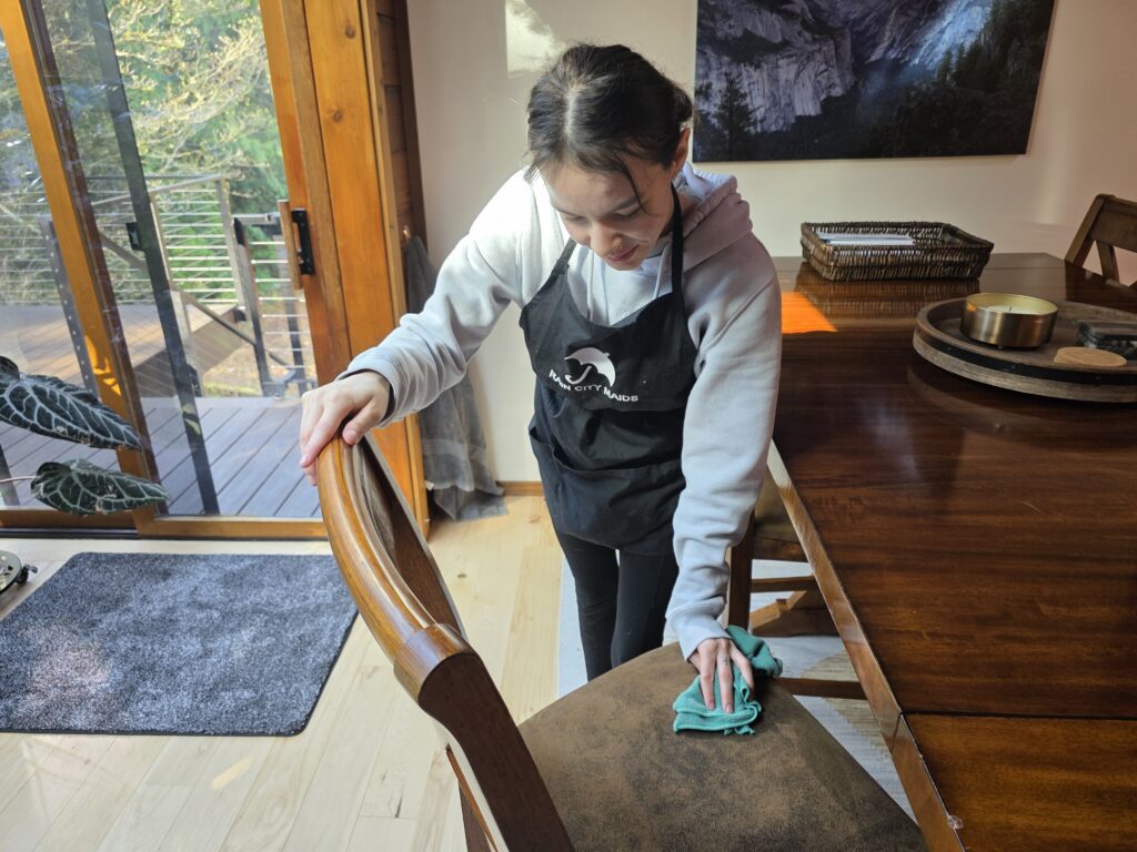 A Rain City Maids cleaner cleaning a dining area