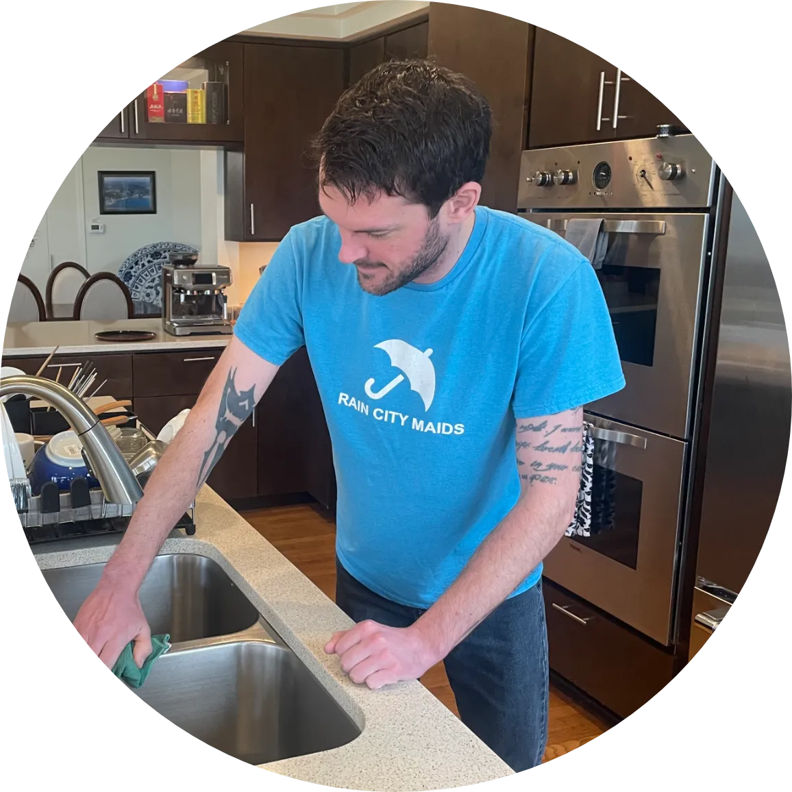 A Rain City Maids house cleaner cleaning a kitchen sink