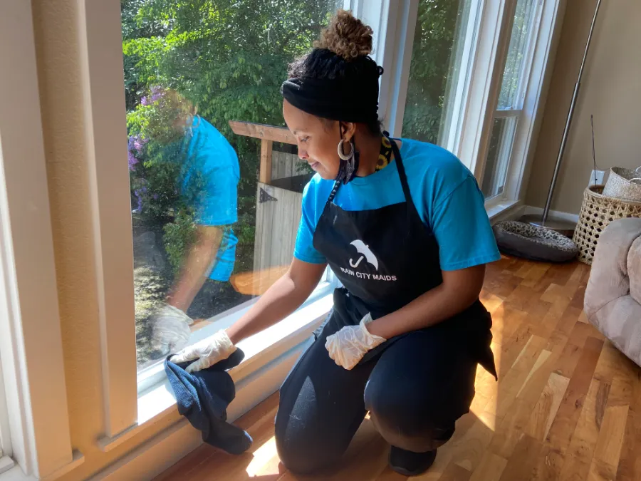 A Rain City Maids cleaner washing a window