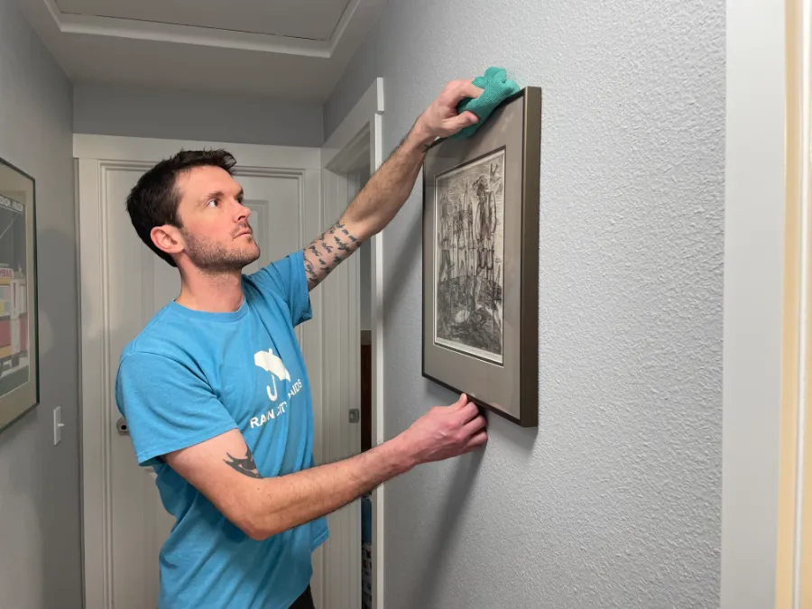 A Rain City Maids cleaner dusting a picture frame