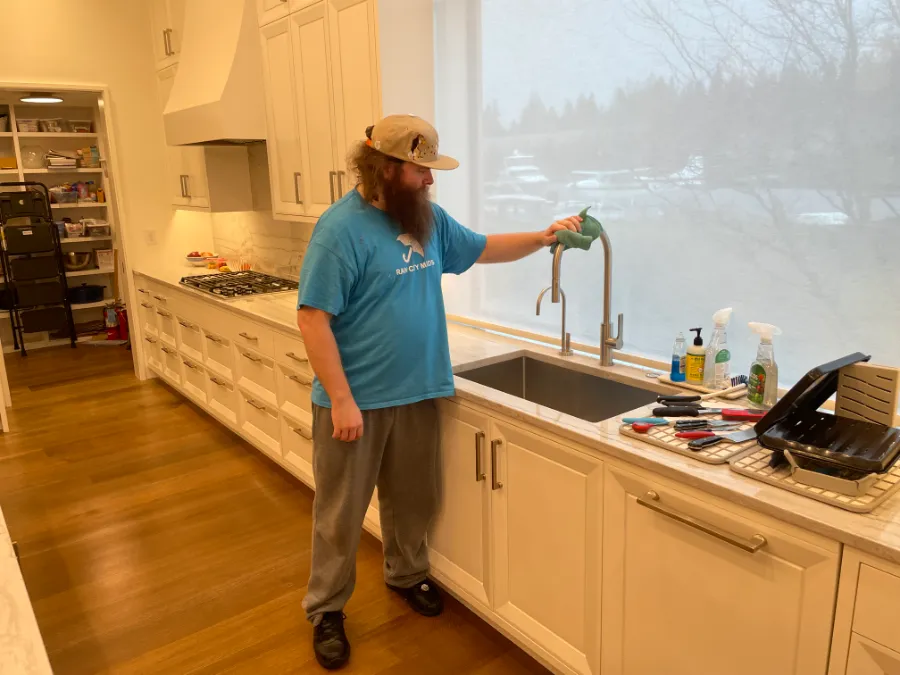 A Rain City Maids cleaner cleaning a kitchen
