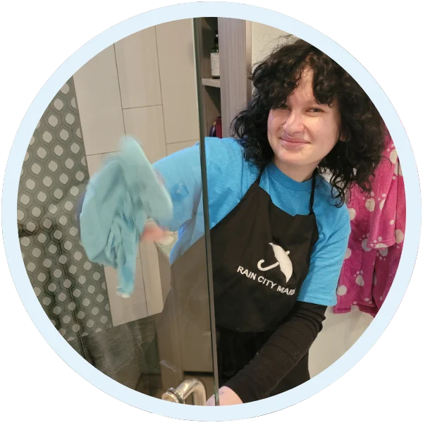 Rain City Maids cleaner wiping a shower door